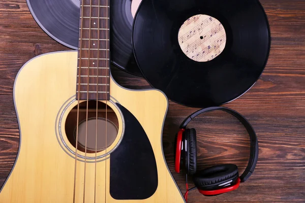 Chitarra con dischi in vinile e cuffie su tavolo in legno da vicino — Foto Stock