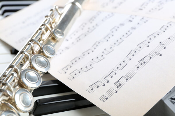 Флейта и фортепиано с нотами вблизи
