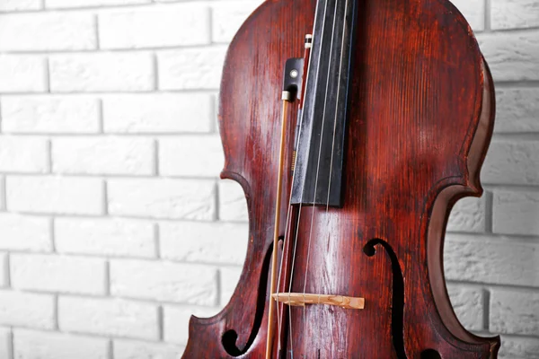 Violoncelo em tijolos fundo da parede — Fotografia de Stock