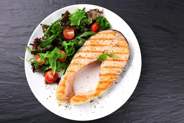 Вкусный лосось с салатом на столе. — стоковое фото