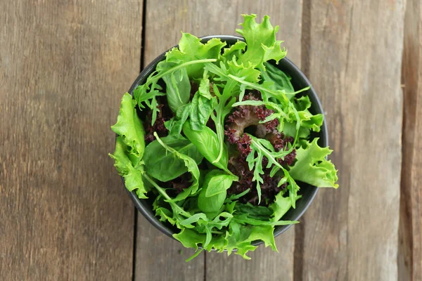 Ahşap zemin üzerine karışık yeşil salata kâsesi — Stok fotoğraf