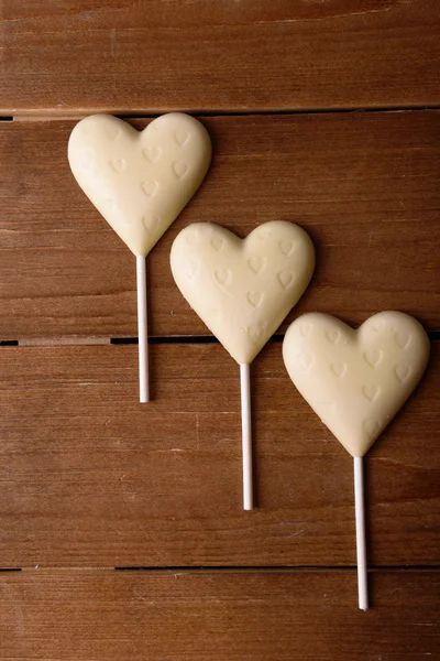 Chocolade snoepjes in de vorm van harten op houten achtergrond — Stockfoto