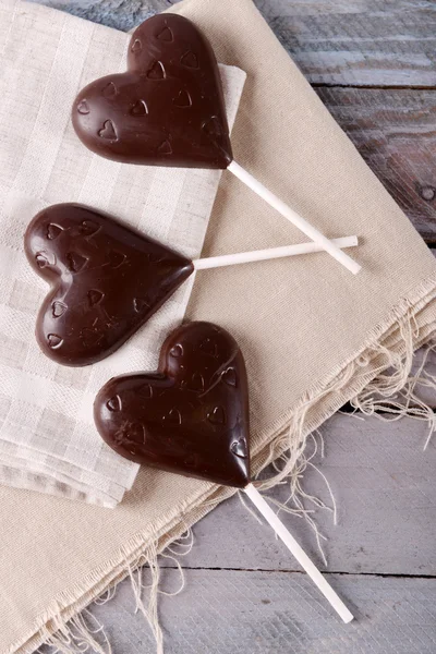 Caramelle a forma di cuore di cioccolato su bastoncini su sacco, primo piano — Foto Stock