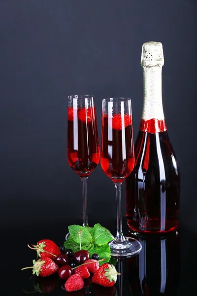 Glasses of champagne with berries on black background — Stock Photo, Image