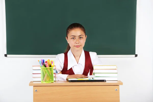 Bela colegial em sala de aula perto de quadro negro — Fotografia de Stock