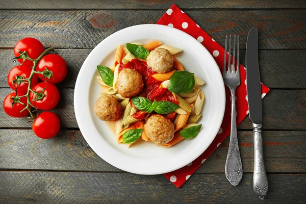 Pasta with meatballs on plate, on wooden  table background — Stock Photo, Image