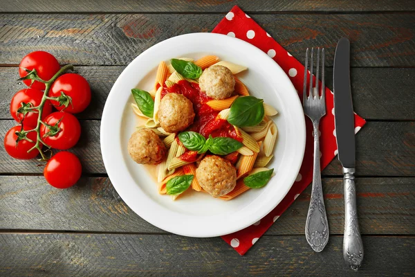 Pasta con polpette su piatto, su fondo tavola in legno — Foto Stock