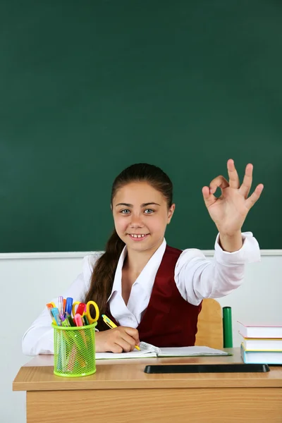 Vacker liten skolflicka i klassrummet nära blackboard — Stockfoto