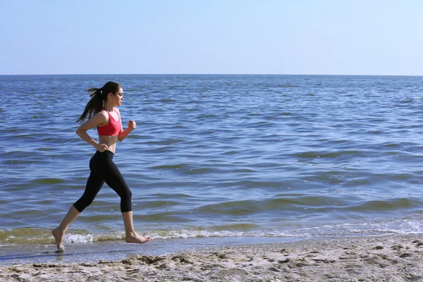 Young woman jogging on beach — Stock Photo, Image
