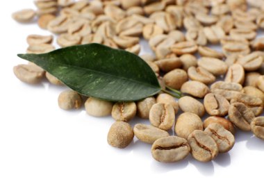 Yeşil kahve çekirdekleri ile üzerine beyaz izole yaprak yığını