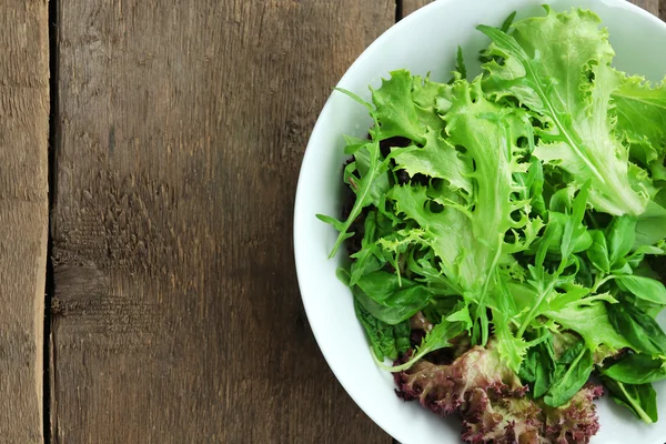 Bol de salade verte mélangée sur fond en bois — Photo