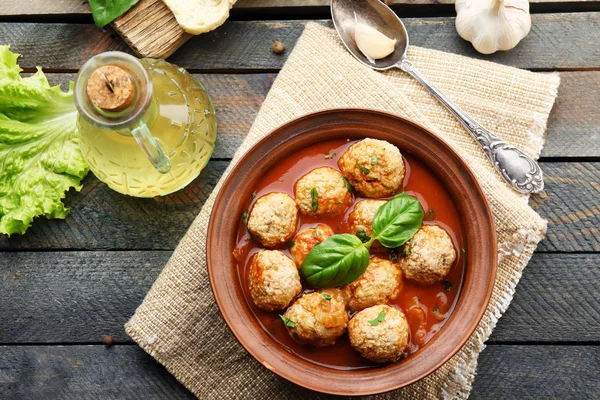 Bolas de carne con salsa de tomate, cuchara de madera sobre fondo de madera — Foto de Stock