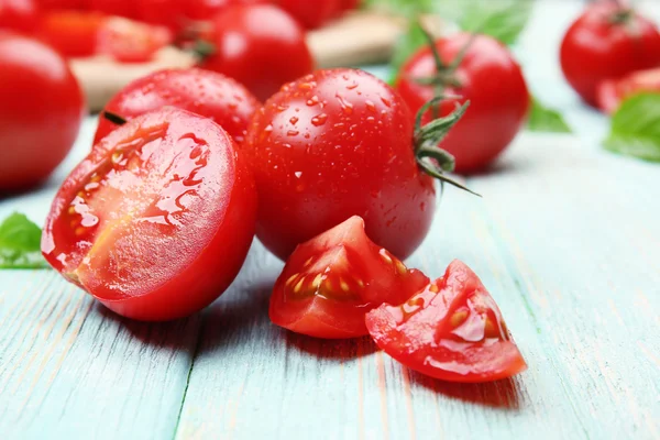 Świeże pomidory z bazylią na drewnianym stole z bliska — Zdjęcie stockowe
