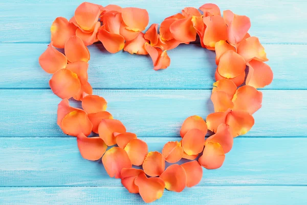 Hermoso corazón de pétalos de rosa sobre fondo de madera — Foto de Stock