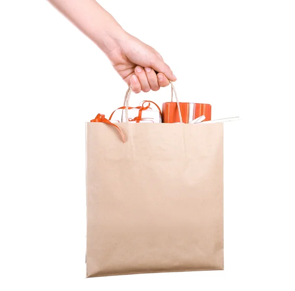 Female hand holding paper bag with present boxes isolated on white — Stock Photo, Image