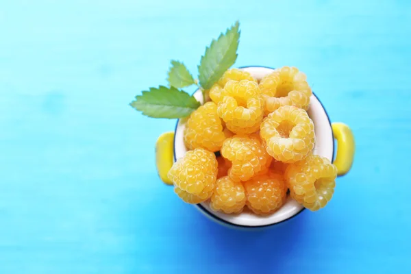 Yellow raspberries on turquoise table, top view — Stock Photo, Image
