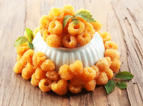 Yellow raspberries in bowl on wooden background — Stock Photo, Image