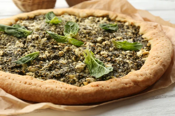 Open pie met spinazie op tafel close-up — Stockfoto