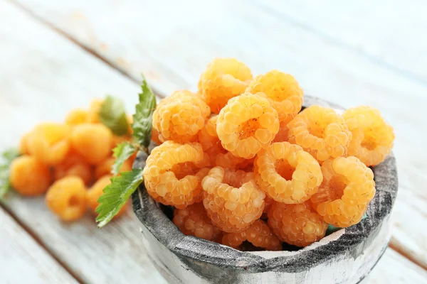 Yellow raspberries in cup on wooden table, closeup — Stock Photo, Image