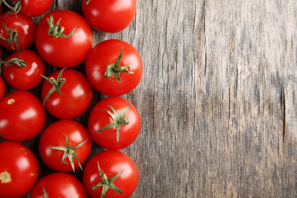 Pile of cherry tomatoes on wooden background — Stock Photo, Image