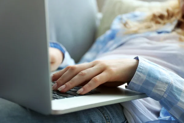 Жінка використовує ноутбук, в приміщенні — стокове фото