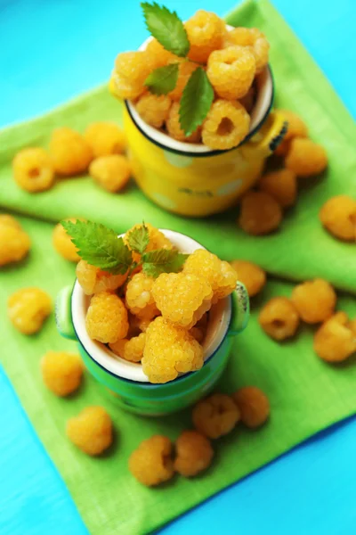 Yellow raspberries in cups on green napkins, closeup — Stock Photo, Image