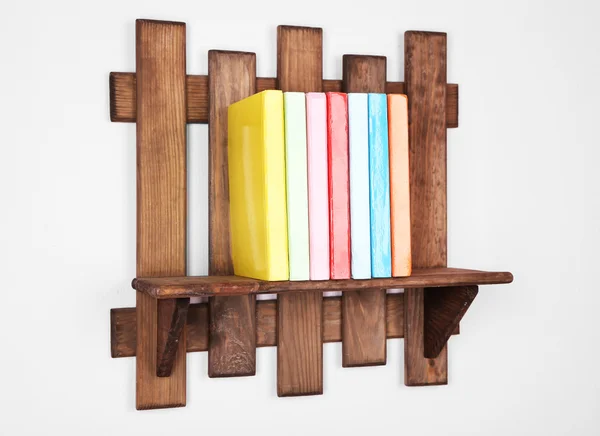 Prateleira de madeira com livros no fundo da parede — Fotografia de Stock