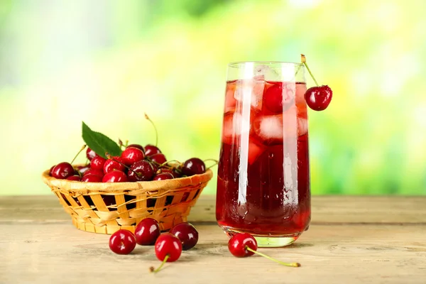 Glas frischer Saft mit Kirschen auf hellem Hintergrund — Stockfoto