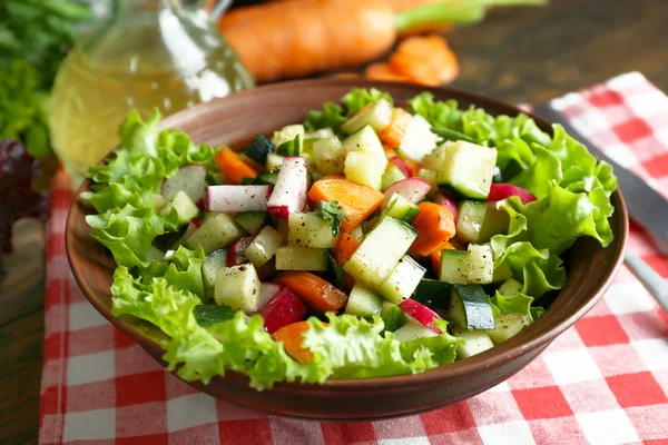 Wooden bowl of fresh vegetable salad on napkin, closeup — Stock Photo, Image