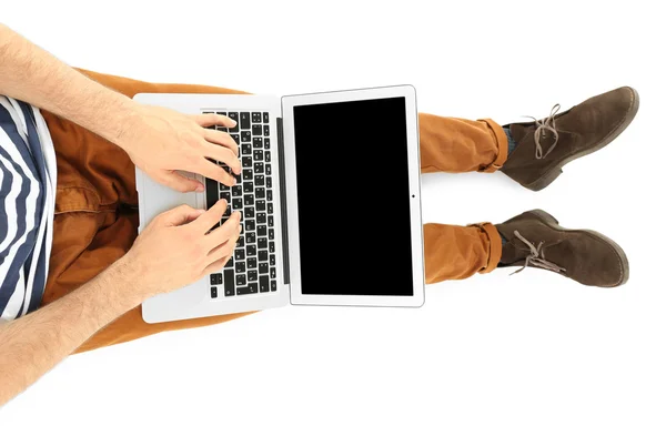 Jonge man zitten met laptop geïsoleerd op wit — Stockfoto