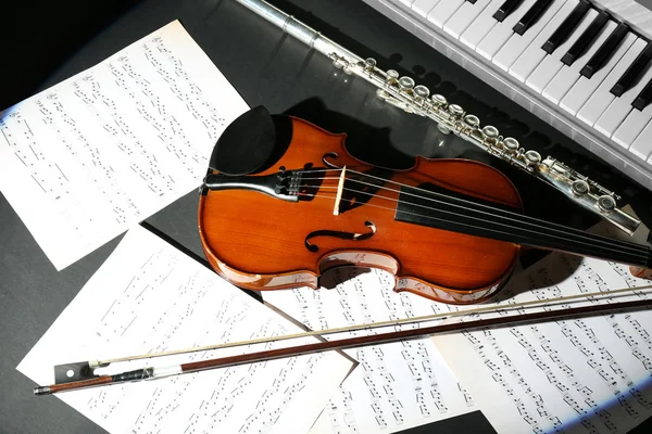 Instrumentos musicais com notas de música sobre fundo escuro — Fotografia de Stock