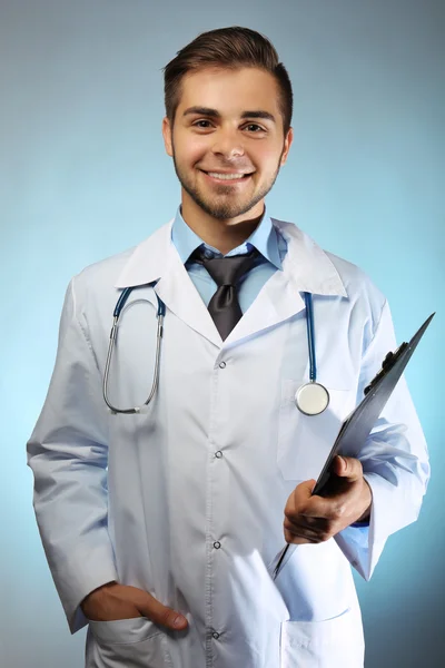 Mężczyzna lekarz z folderu na niebieskim tle — Zdjęcie stockowe