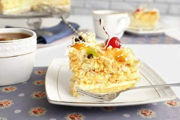 Peace of tasty Butter cake on plate, tea cups on color wooden background — Stock Photo, Image