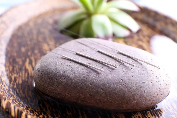 Akupunktur nålar med spa sten på bricka, närbild — Stockfoto