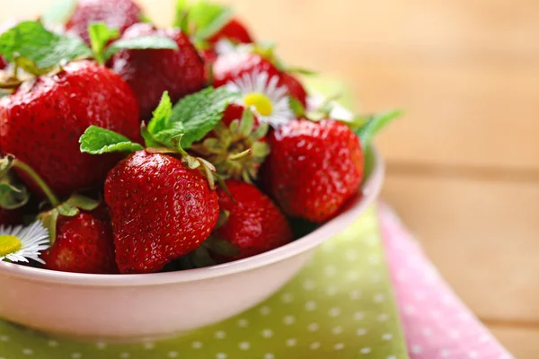 在碗里，颜色木制背景上的红色成熟的草莓 — 图库照片