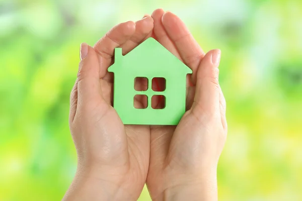 Female hands holding model of house on bright background — Stock Photo, Image