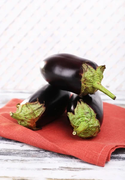 Färska aubergine på servett träbord, närbild — Stockfoto