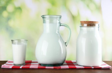 Sürahi, kavanoz ve süt doğa arka plan üzerinde ahşap tablo