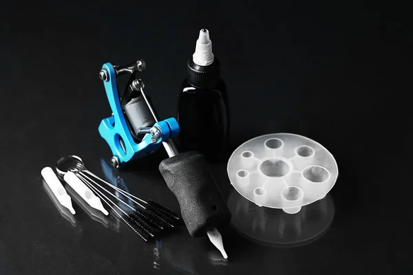 Tätowiermaschine und Tätowierzubehör, auf dunklem Hintergrund — Stockfoto