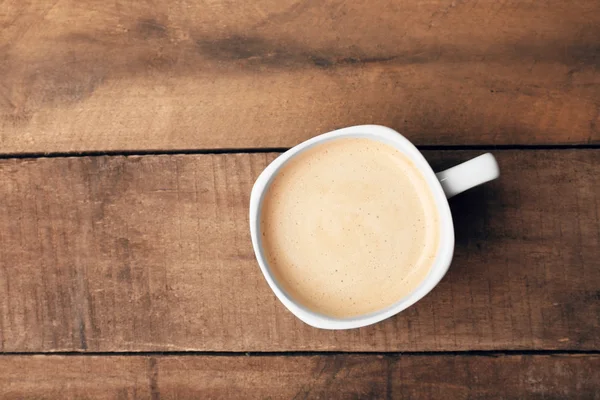 Secangkir kopi di atas meja kayu, pemandangan atas — Stok Foto