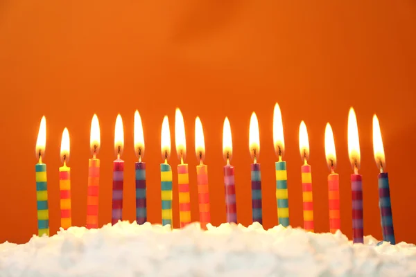 Торт на день народження зі свічками на кольоровому фоні — стокове фото