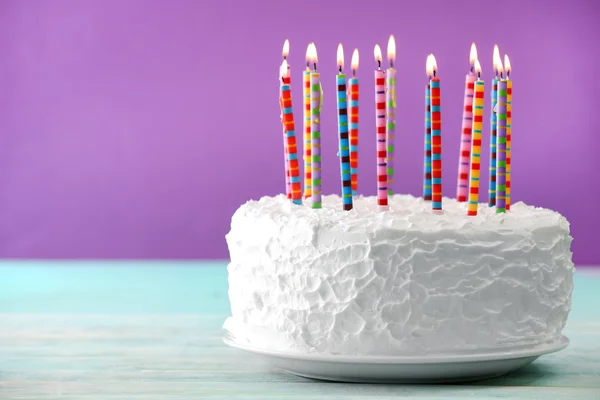 Gâteau d'anniversaire avec des bougies sur fond de couleur — Photo