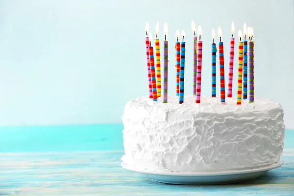 Torta di compleanno con candele su sfondo chiaro — Foto Stock