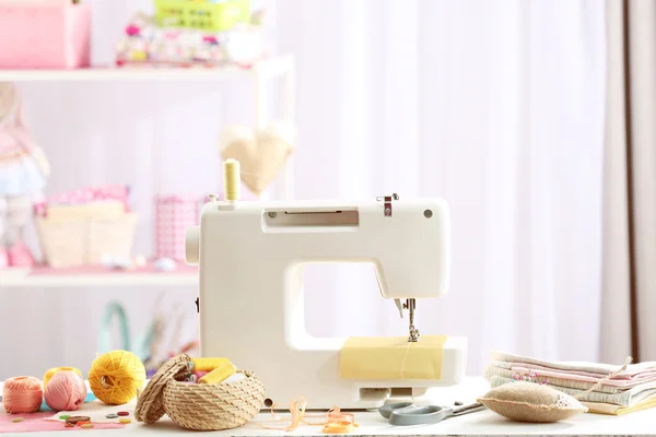 Швейная машина на столе в мастерской — стоковое фото