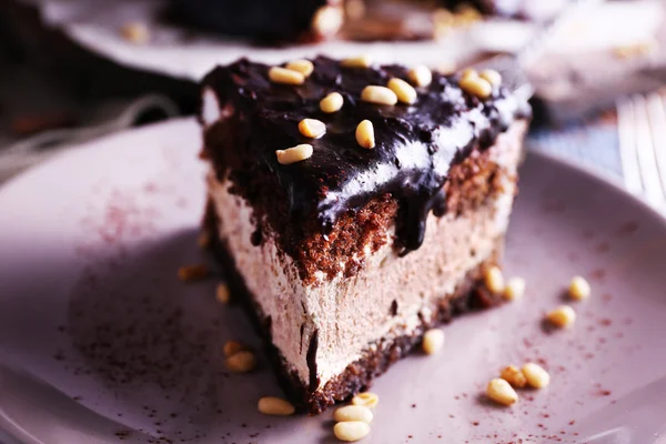 Delicioso pastel de chocolate con hielo en el plato en la mesa, primer plano —  Fotos de Stock