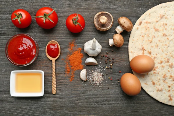 Ingrediënten voor het koken van pizza op houten tafel, bovenaanzicht — Stockfoto