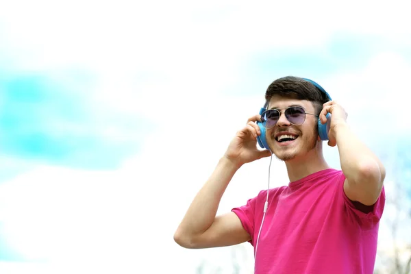 Homem com fones de ouvido sobre fundo céu azul — Fotografia de Stock