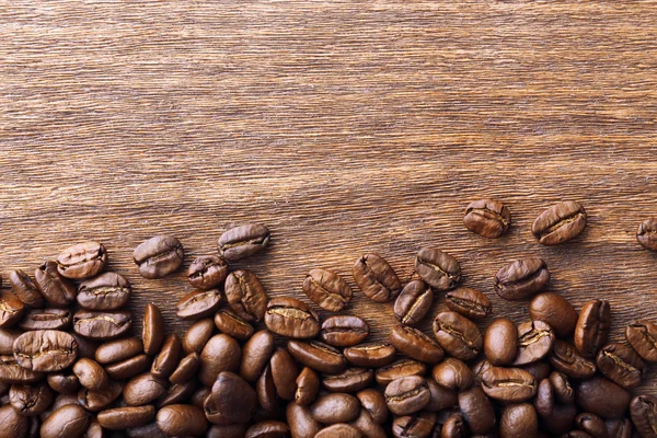 Grains de café sur fond en bois — Photo