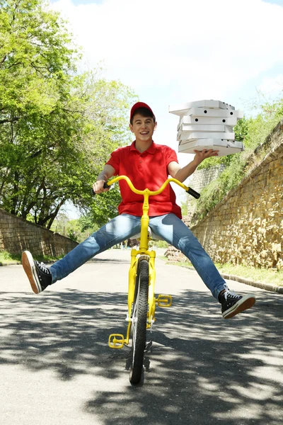 Young man delivering pizza box on bike outdoors — Stock Photo, Image