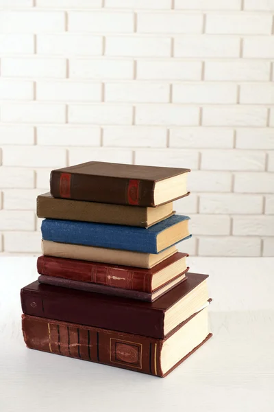 Heap of old books on brick wall background — Stock Photo, Image